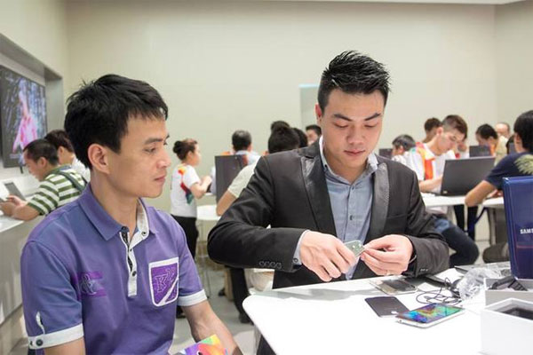 Anh Trần Văn Dũng (Cầu Giấy) đang chờ cắt SIM để dùng ngay với chiếc điện thoại mới Galaxy S5 đã mở bán tại Hà Nội và TP HCM