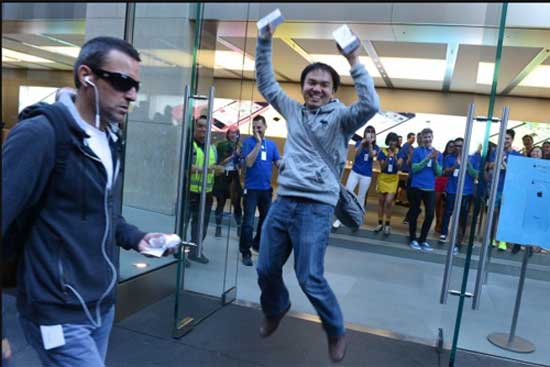 Anh Jimmy Gunawan khoe hai chiếc iPhone của mình sau khi trở thành người đầu tiên sở hữu Không khí ngày bán iPhone 5S, iPhone 5C đầu tiên trên thế giới