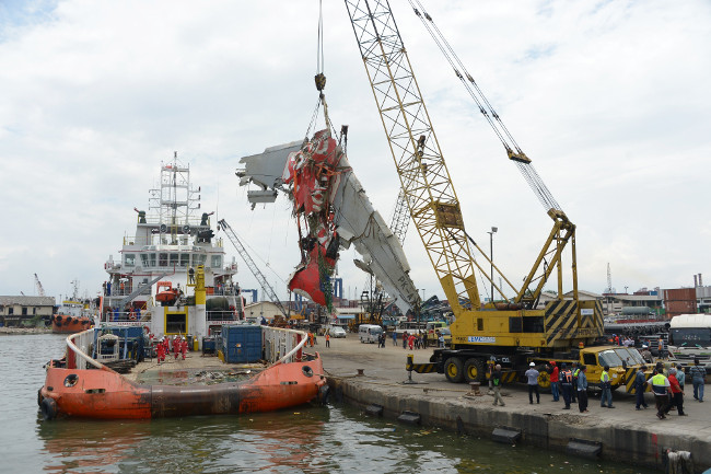 Một chiếc cần cẩu bốc dỡ mảnh vỡ máy bay QZ8501 được trục vớt từ tàu cứu hộ sang cảng Một chiếc cần cẩu bốc dỡ mảnh vỡ máy bay QZ8501 được trục vớt từ tàu cứu hộ sang cảng