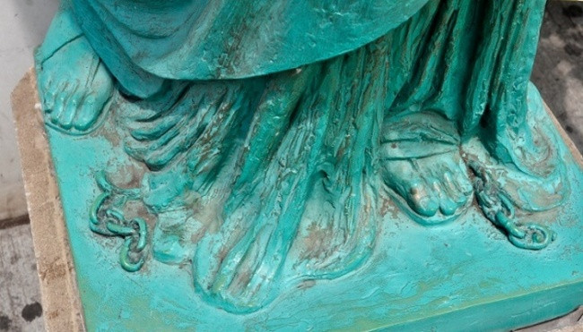 Chuỗi xích bị đứt nằm dưới chân tượng Nữ thần Tự do Chuỗi xích bị đứt nằm dưới chân tượng Nữ thần Tự do