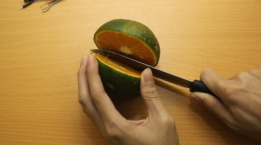 Cắt đôi quả cam thành 2 nửa theo chiều ngang