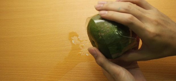 Úp 2 nửa quả cam lại với nhau và cố định bằng băng dính