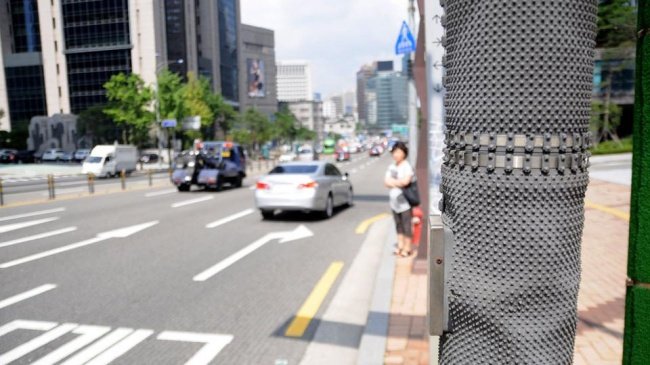 Tấm bìa bọc bên ngoài cột đèn xanh đèn đỏ giúp ngăn chặn dán poster hoặc quảng cáo trên đó.