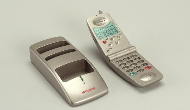 Điện thoại Talisman và giá đỡ đi kèm được thiết kế bởi Takanobu Fujimoto, Greg Breiding, Seiji Wada, Takeshi Tsuruta, Keith Kresge và Deane Richardson, Công ty Điện tử Mitsubishi và Fitch Inc