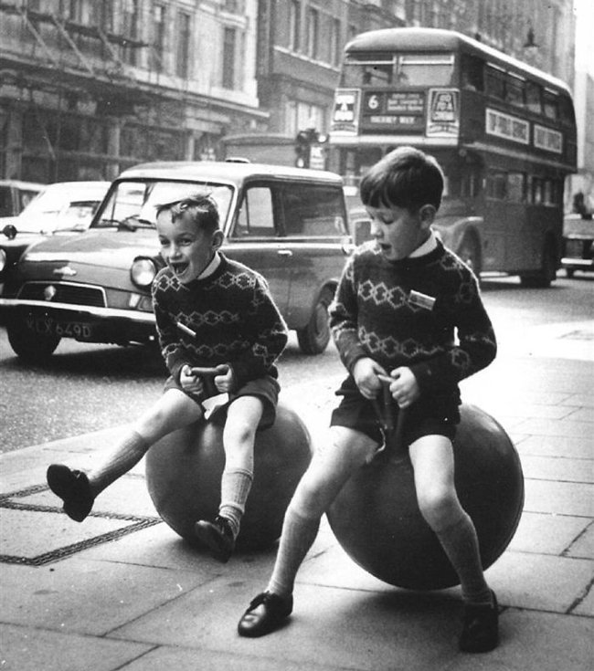 Hai đứa trẻ đang chơi bóng nhún trên đường phố Luân Đôn