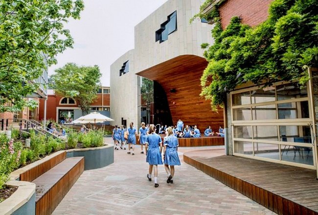 Một góc sân khấu nhỏ ở lối vào trường, nơi học sinh có thể biểu diễn hoặc tận hưởng ánh nắng mặt trời và không khí trong lành.