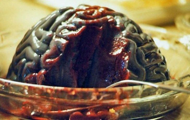 Các vị khách dùng thìa múc óc còn tươi ăn với rau gia vị trong khi con khỉ vẫn còn đang kêu la