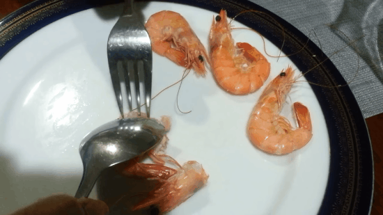 Dùng thìa giữ chặt thân con tôm 