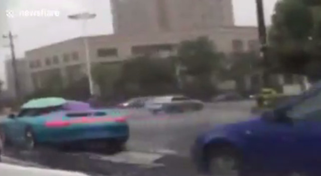 Kỳ khôi chuyện đi xe hạng sang, không hạ mái mà dùng dù che mưa gây sốc