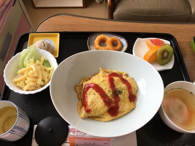 Omuraisu egg roll, pasta salad, chicken soup, fried squid, fruit and green tea