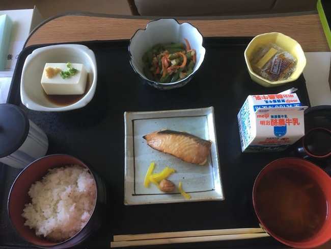 Salmon, tofu, spinach salad, natto (a dish made with soybeans), miso soup, rice and milk