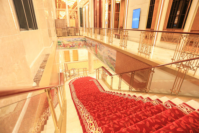 Cầu thang bộ lớn dẫn lên tầng 2, khu vực tổ chức yến tiệc được trải thảm đỏ 