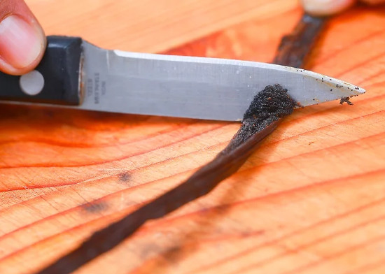 Cắt nửa quả vani theo chiều dọc. Vét hết hạt và để dành.