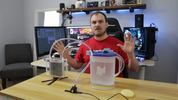 Anh chàng dùng 2 đường ống nối với một máy bơm nhỏ cùng một thùng nước đá để đưa nước lã vào cái hộp