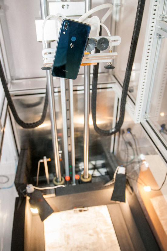 Hệ thống máy tự động nâng chiếc điện thoại Vsmart lên các độ cao khác nhau và thả rơi xuống một mặt bê tông cứng