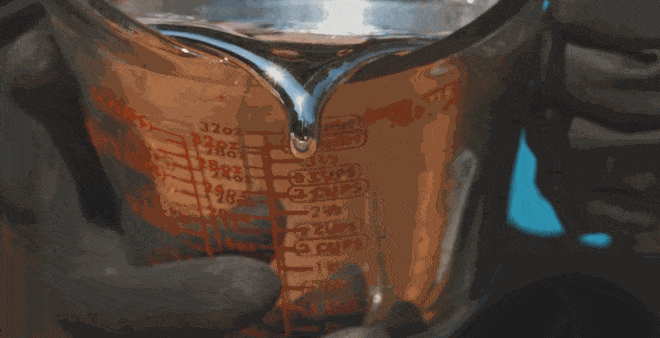 Hình ảnh quay chậm cảnh đổ Gallium từ một chiếc cốc lớn