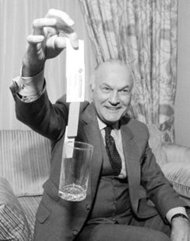 Harry Coover thử nghiệm keo siêu bền bằng giấy và cốc.