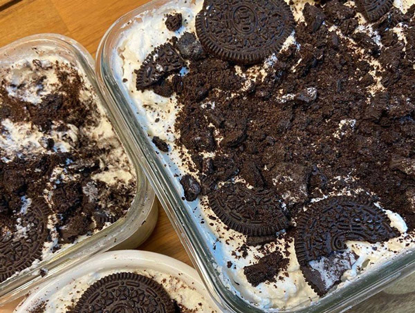 Rải hỗn hợp kem đã đánh đều xuống dưới đáy hộp, sau đó rải 1 lớp vụn bánh Oreo đen lên trên