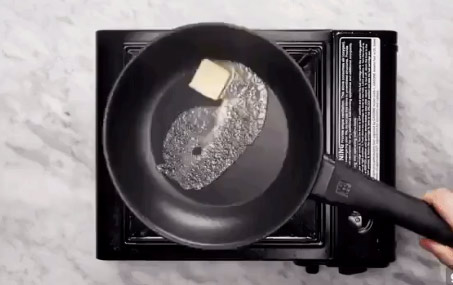 Cho chảo lên bếp, tráng khắp mặt chảo bằng một lớp bơ mỏng