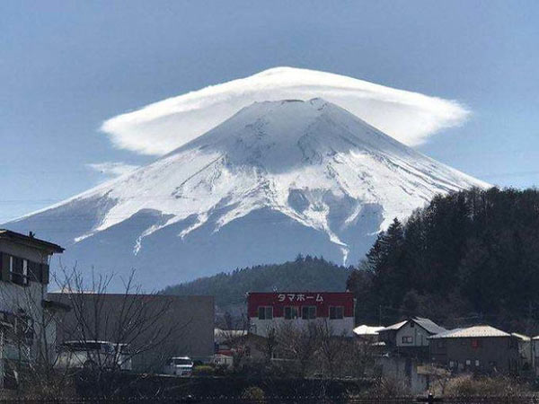 A giant umbrella-shaped cloud crosses over the top of Mt. Fuji