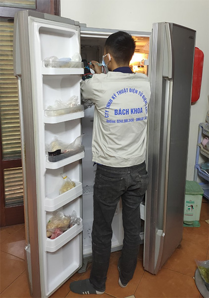 Nhân viên TT điện lạnh 218 đang kiểm tra tủ lạnh cho khách