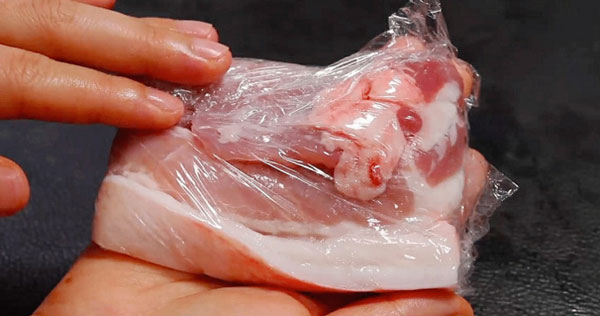 Dùng màng bọc thực phẩm bọc thịt lợn để giữ cho thịt được tươi