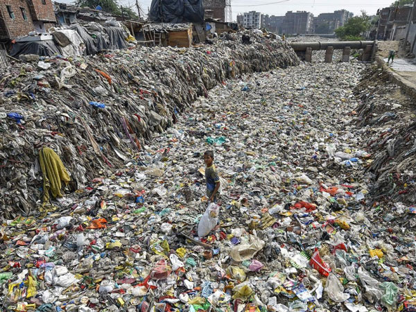 Một cậu bé đang thu thập những món đồ có thể tái chế tại khu cống khô ở Taimoor Nagar, New Delhi, Ấn Độ.