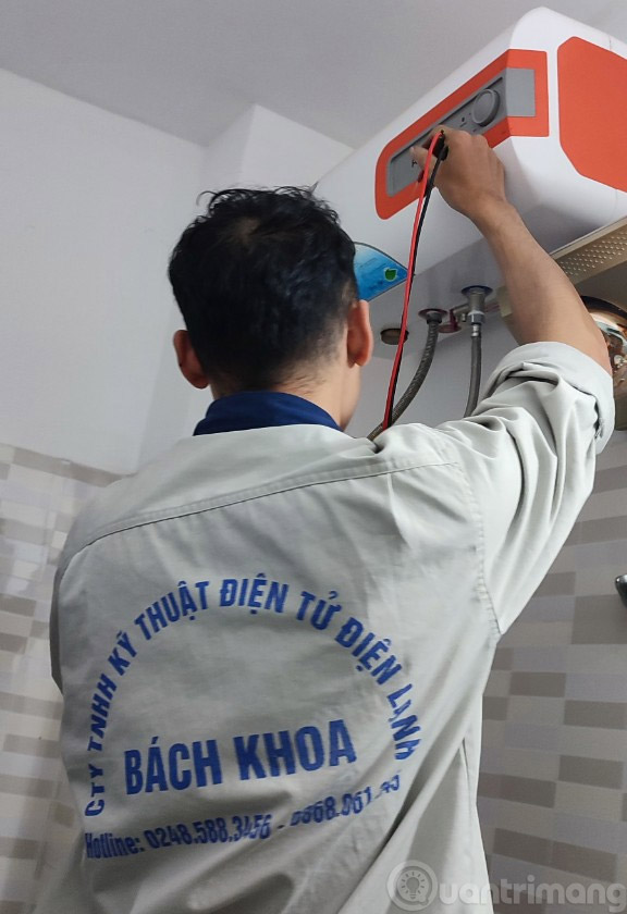 Nhân viên Công Ty TNHH Kỹ Thuật Điện Tử Điện Lạnh Bách Khoa đang sửa bình nóng lạnh cho khách
