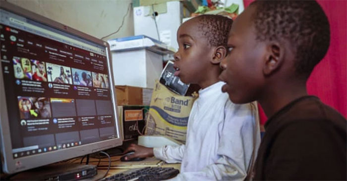 Hai cậu bé sử dụng chung 1 máy tính để lên mạng tại một quán cà phê Internet ở Nairobi, Kenya. Ảnh: Brian Inganga / AP
