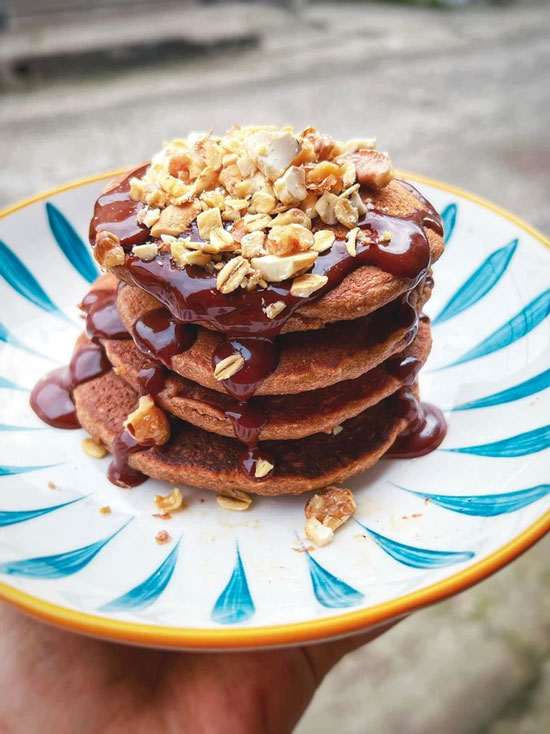 Bữa sáng với bánh pancake nguyên cám sô-cô-la thêm ly sữa hạt.