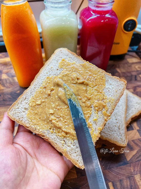 Bánh mì nguyên cám phết bơ lạc tự xay, kèm bình nước ép trái cây cho bữa sáng đầy đủ dinh dưỡng và ngon miệng. 