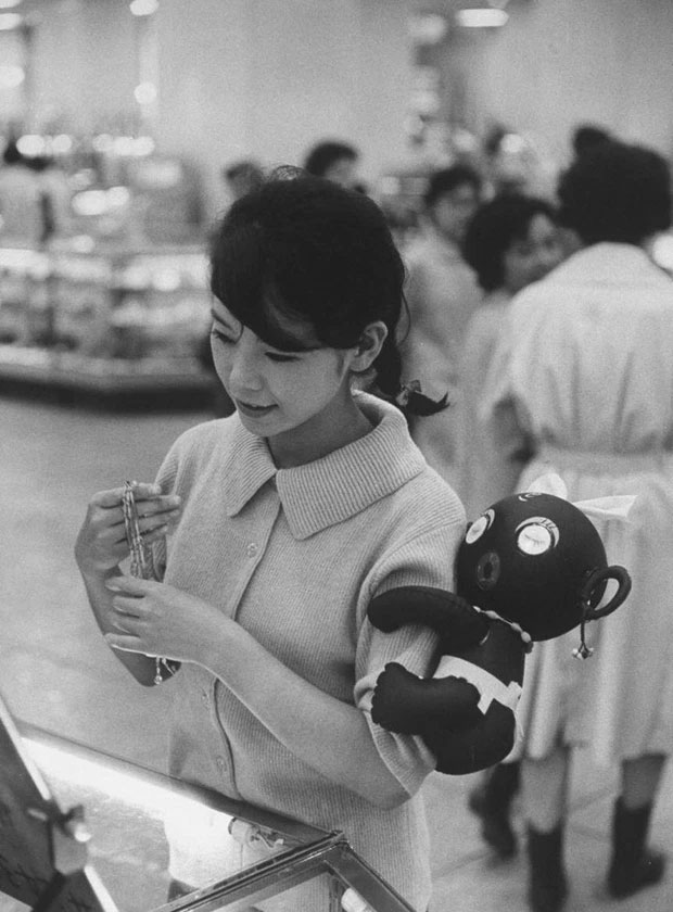 Một phụ nữ đeo đồ chơi Dakko-chan trên tay, một trào lưu kỳ lạ ở Nhật Bản năm 1960.