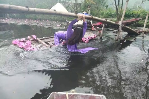 Chèo thuyền chụp ảnh với hoa súng nhưng không hiểu sao lại trở thành "đu xà". Ảnh đẹp đâu không thấy mà lại có được kiểu ảnh để đời thế này.