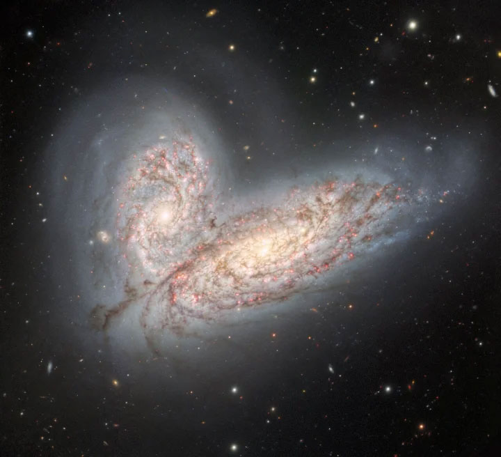 Hình ảnh cho thấy một cặp thiên hà xoắn ốc - NGC 4568 (dưới cùng) và NGC 4567 (trên) - khi chúng bắt đầu xung đột và hợp nhất. Quá trình này cuối cùng sẽ tạo thành một thiên hà hình elip duy nhất trong khoảng 500 triệu năm nữa.