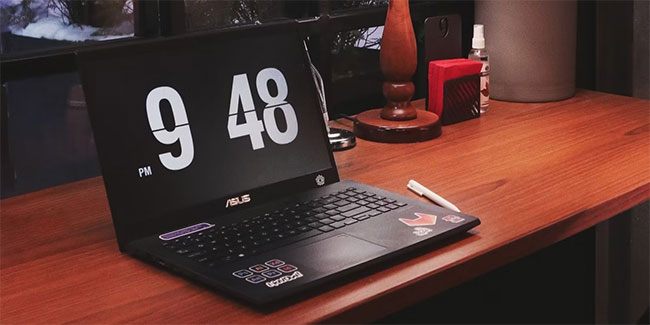 Một chiếc máy tính xách tay Asus màu đen trên bàn gỗ