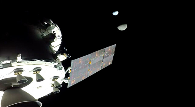 Bức ảnh cho thấy một phần của con tàu, với mặt trăng và Trái đất ở phía xa.