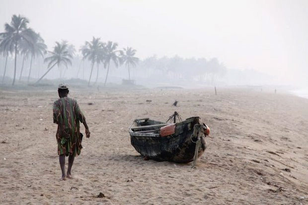 Một người đàn ông say rượu kết thúc đêm của mình trên bãi biển tại Ouidah, Benin, năm 2009.