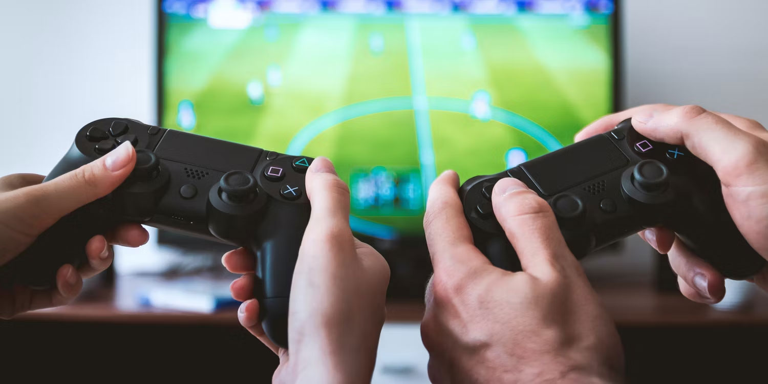 Hai người đang sử dụng tay cầm chơi game màu đen