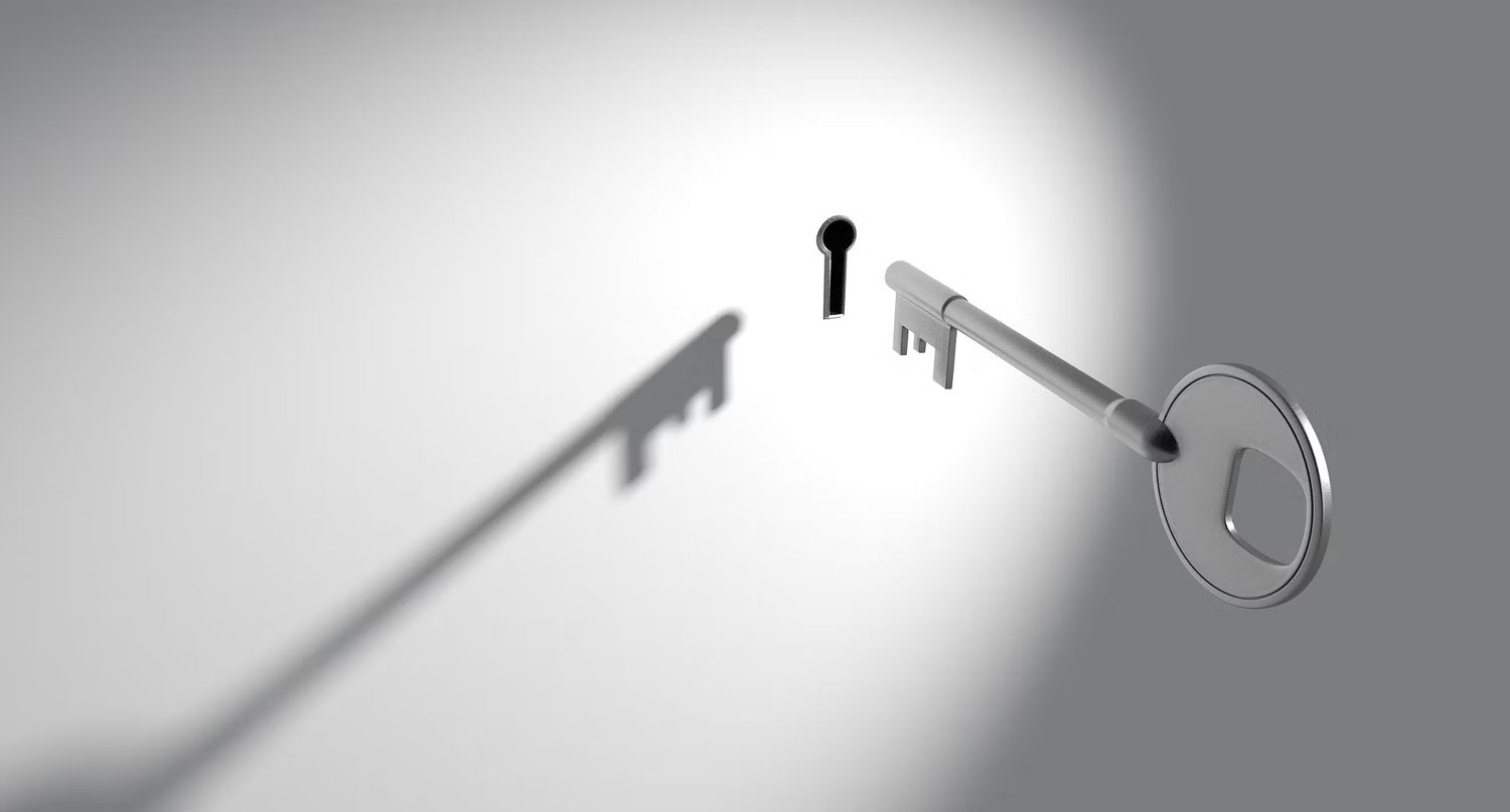 Chìa khóa đi vào lỗ khóa trên bức tường trắng