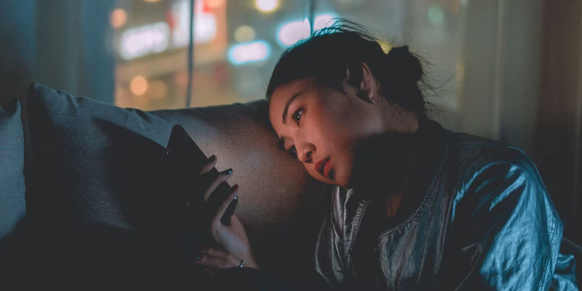 Người phụ nữ buồn chán sử dụng điện thoại