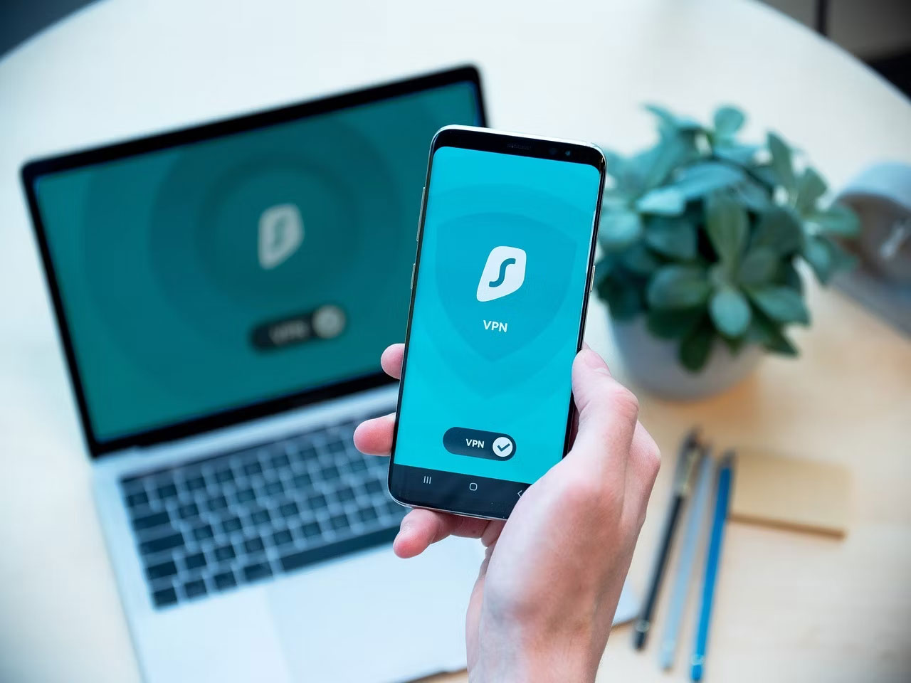 Người đang cầm điện thoại thông minh đã kích hoạt Surfshark VPN