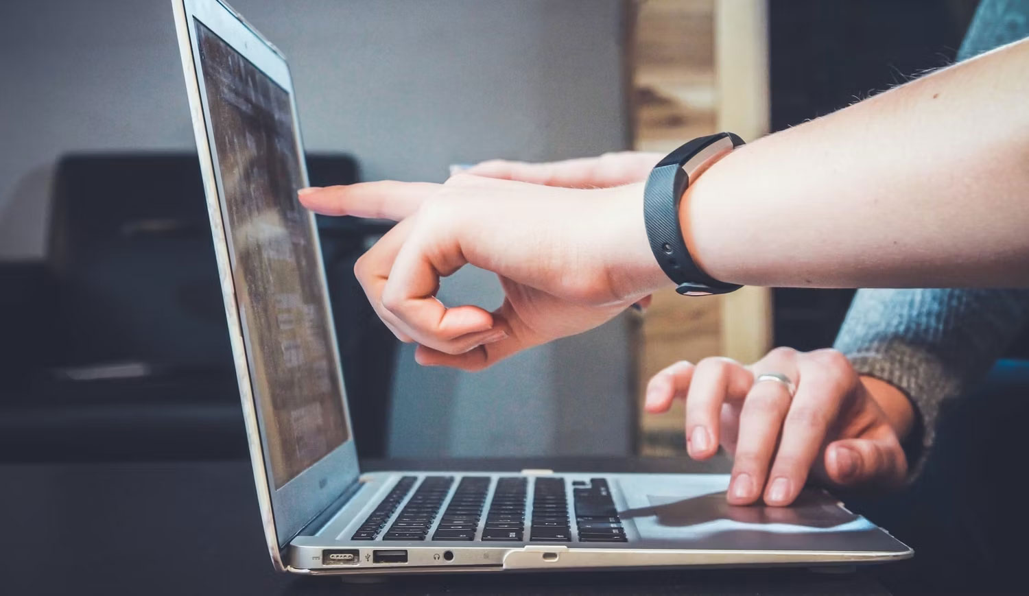 Ngón tay chỉ vào màn hình máy tính xách tay