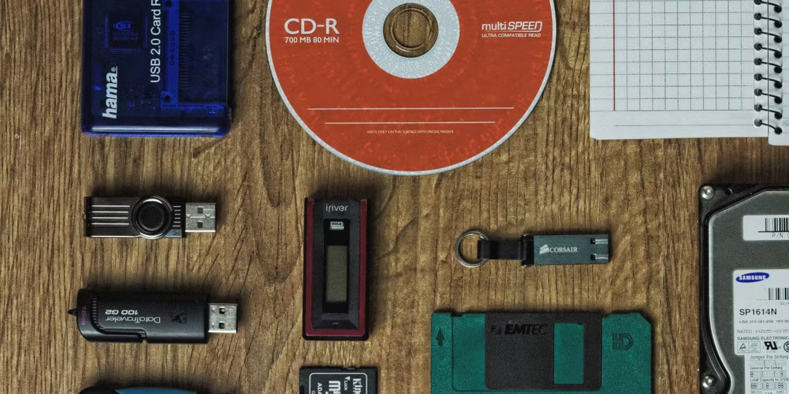 CD, ổ cứng, ổ flash và đĩa mềm trên bề mặt gỗ