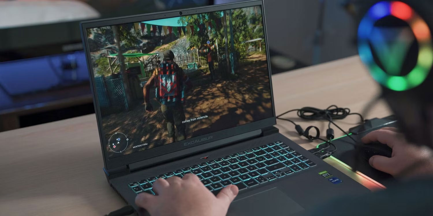 Người đàn ông đeo tai nghe chơi game trên laptop