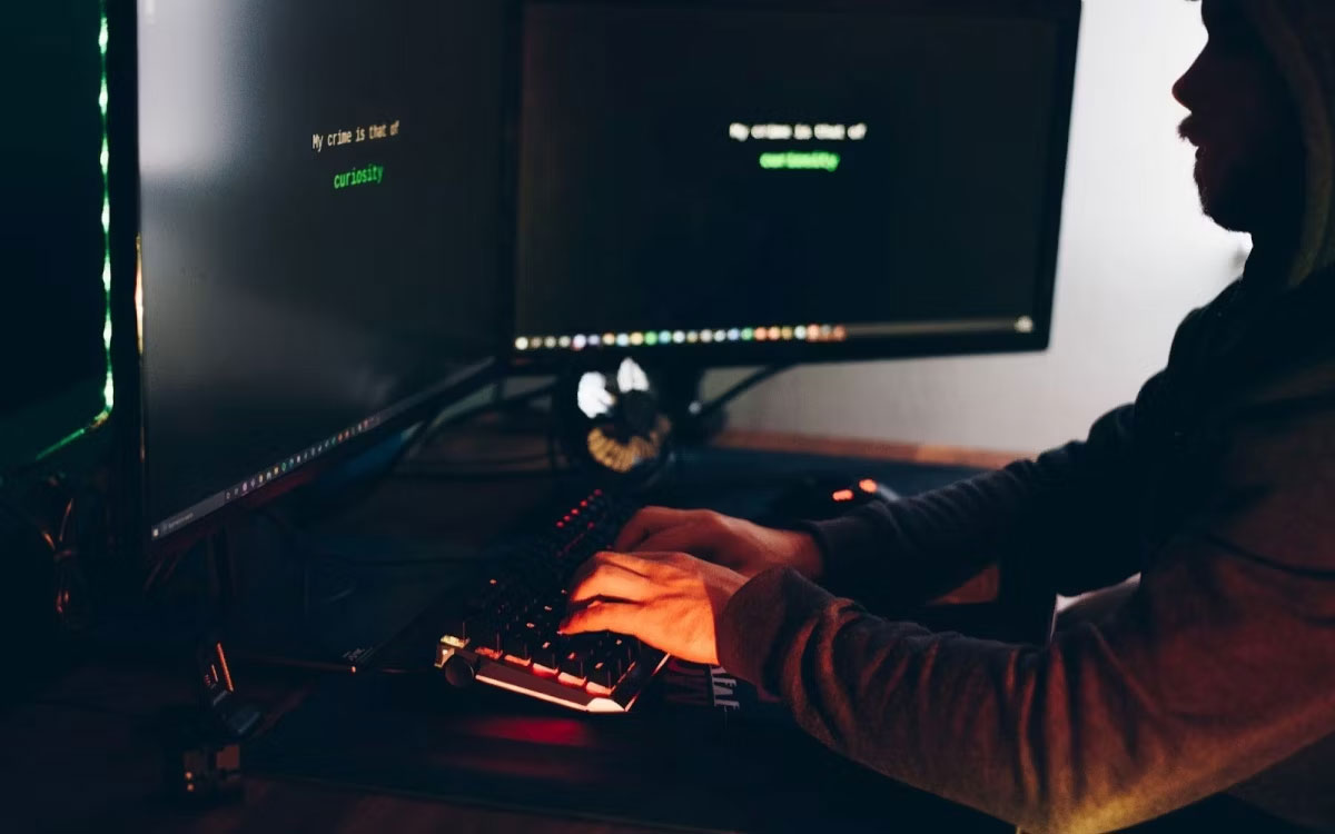 Hacker gõ trên bàn phím trong khi hack hệ thống