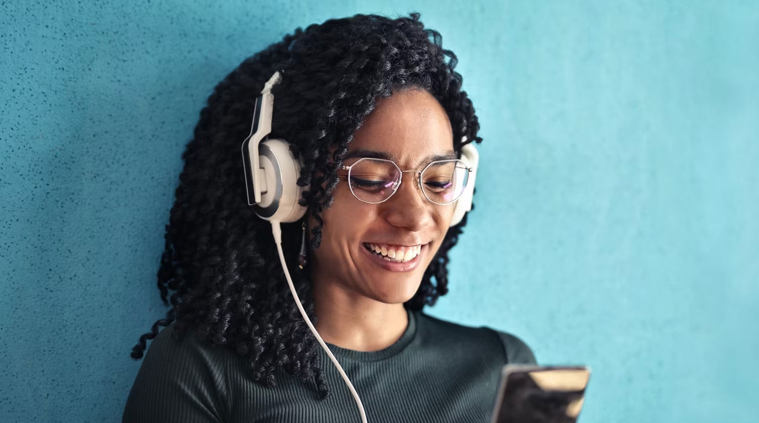 Người phụ nữ đeo tai nghe nhìn vào điện thoại