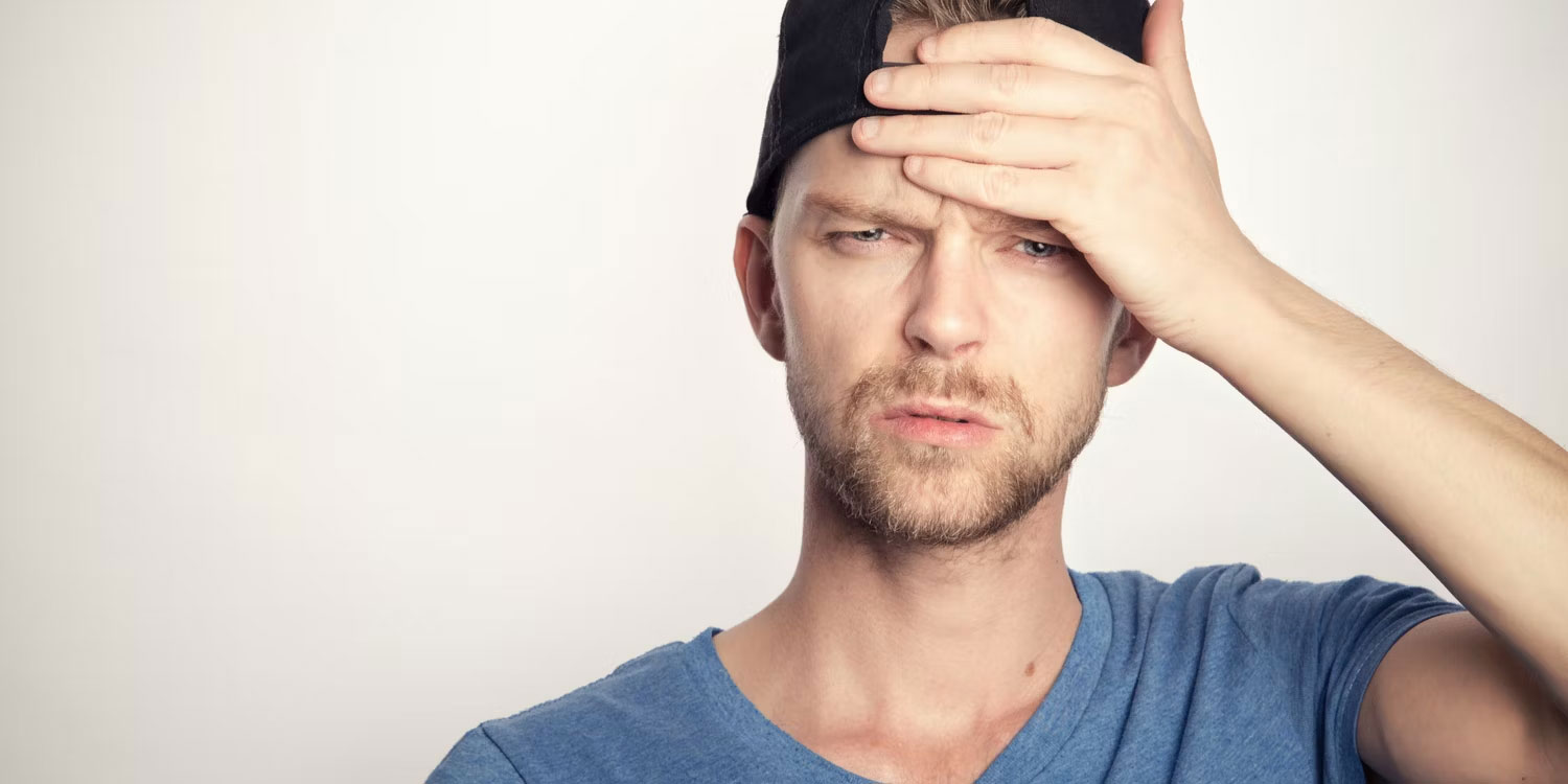 Chàng trai đặt lòng bàn tay lên trán