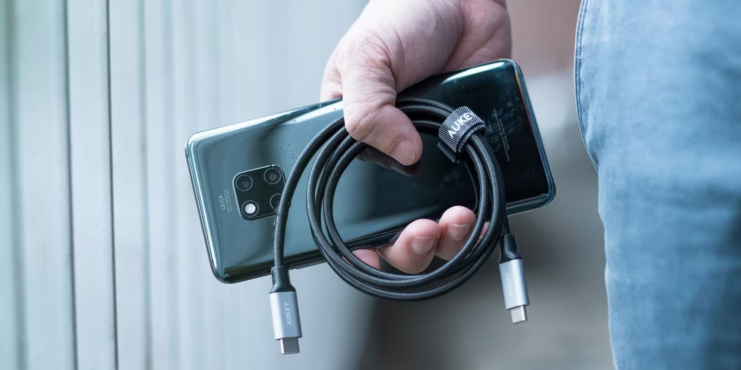 Người có điện thoại thông minh hiện đại và cáp USB