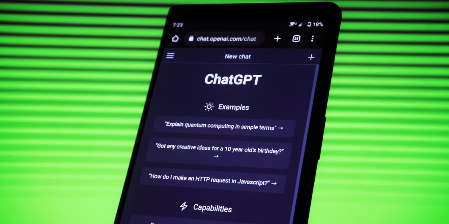 Một chiếc điện thoại trên nền xanh lục với ChatGPT đang mở trên màn hình.