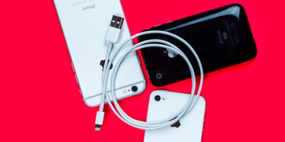 Cáp Lightning to USB màu trắng và 3 chiếc iPhone
